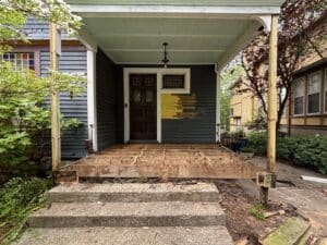 porch restoration project under construction with floor framing exposed