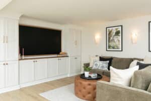 finished basement remodel corner of room with white cabinets, framed TV, and vinyl plank flooring