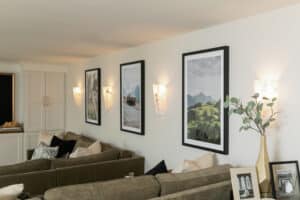 Close up of wall sconce lights and framed art on basement wall