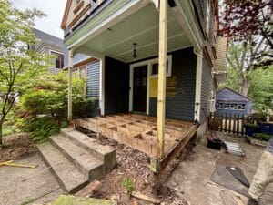 porch restoration project under construction with floor framing exposed
